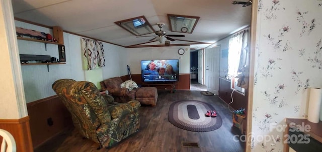 interior space with wainscoting, wood finished floors, a ceiling fan, and crown molding