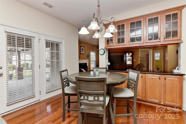 dining area with a wealth of natural light, a chandelier, and dark hardwood / wood-style floors