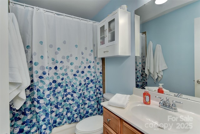 bathroom featuring a shower with curtain, vanity, and toilet