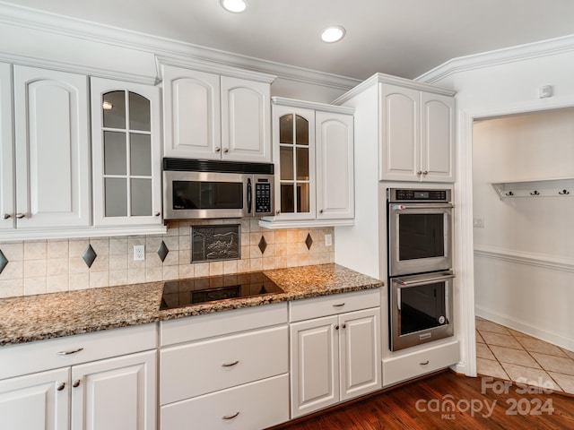 kitchen featuring dark wood-type flooring, white cabinets, stainless steel appliances, and stone countertops