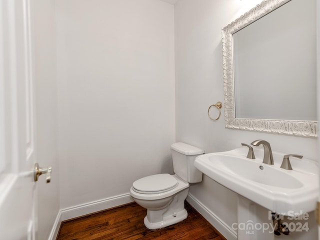 bathroom with hardwood / wood-style floors, toilet, and sink