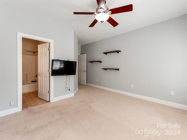 unfurnished bedroom with ensuite bath, light carpet, and ceiling fan