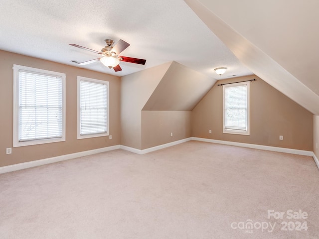 bonus room with a textured ceiling, ceiling fan, lofted ceiling, and light carpet