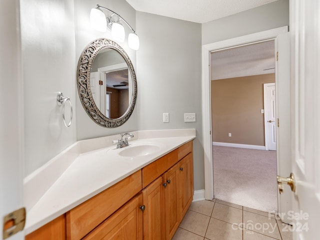 bathroom with tile patterned floors, vanity, and a textured ceiling