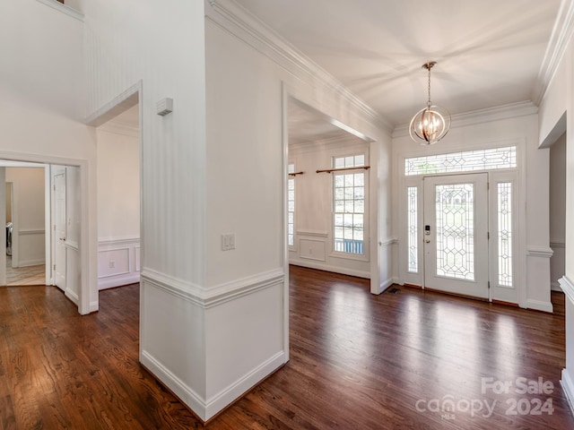 foyer entrance with crown molding, dark wood-type flooring, and a notable chandelier