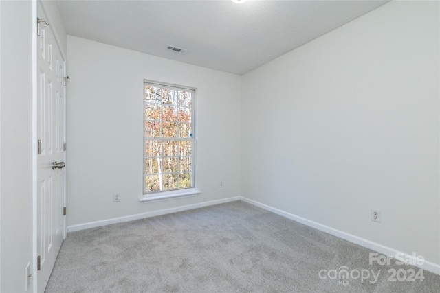 unfurnished room featuring light colored carpet