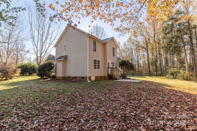 view of property exterior with a patio area and a lawn