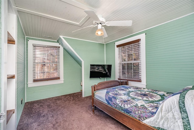 bedroom with ceiling fan, wood walls, and carpet floors