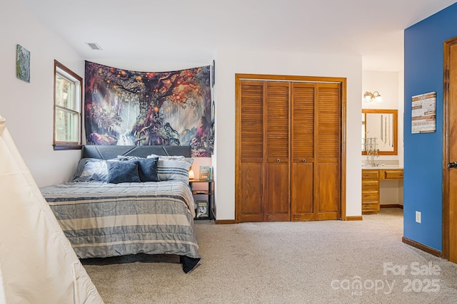 bedroom featuring light colored carpet, connected bathroom, and a closet