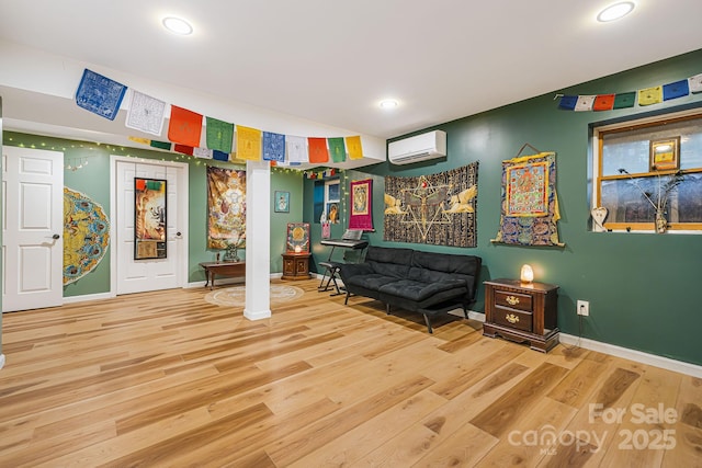 living area with hardwood / wood-style flooring and a wall mounted AC