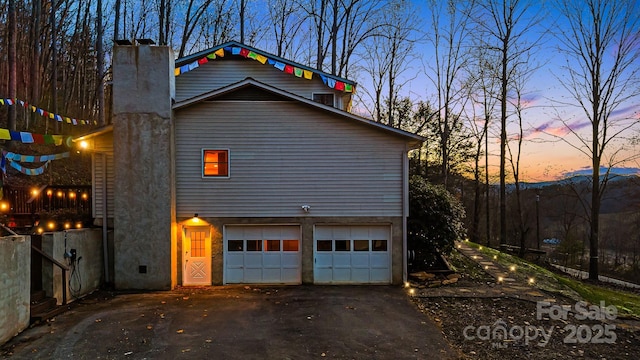 property exterior at dusk featuring a garage