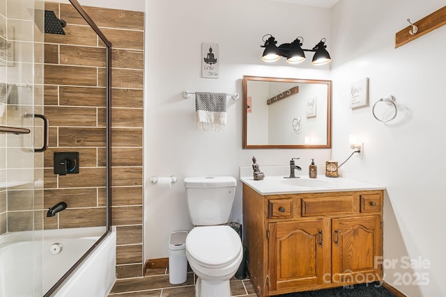 full bathroom featuring toilet, vanity, and bath / shower combo with glass door