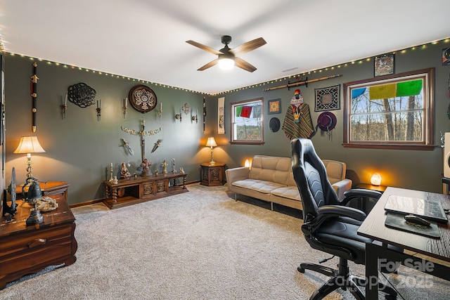 carpeted office space featuring ceiling fan