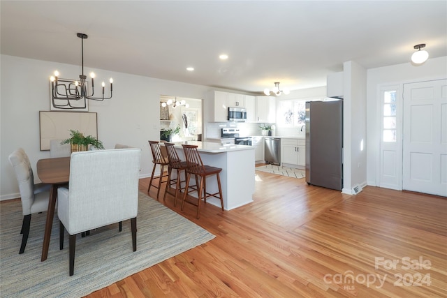 dining area featuring light hardwood / wood-style floors and an inviting chandelier