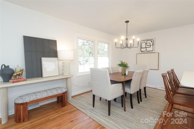 dining space featuring light hardwood / wood-style flooring and a chandelier