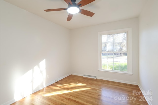 empty room with ceiling fan, a baseboard radiator, and light hardwood / wood-style flooring