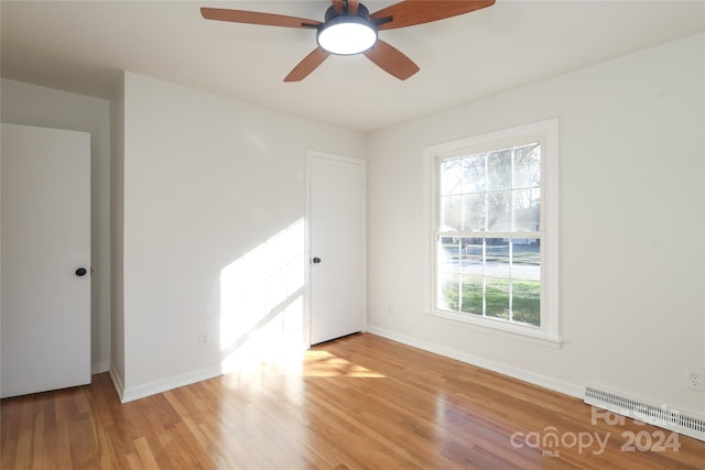 unfurnished room with a wealth of natural light, ceiling fan, and light wood-type flooring