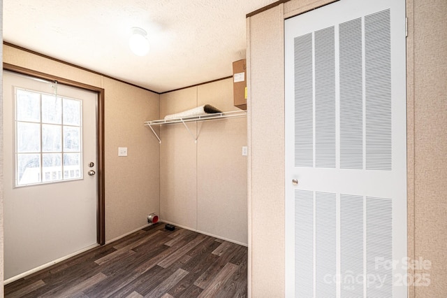 laundry area featuring dark wood-type flooring and a textured ceiling