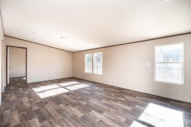 unfurnished room featuring ornamental molding and dark hardwood / wood-style flooring