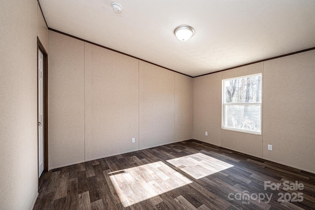 empty room featuring ornamental molding and dark hardwood / wood-style floors