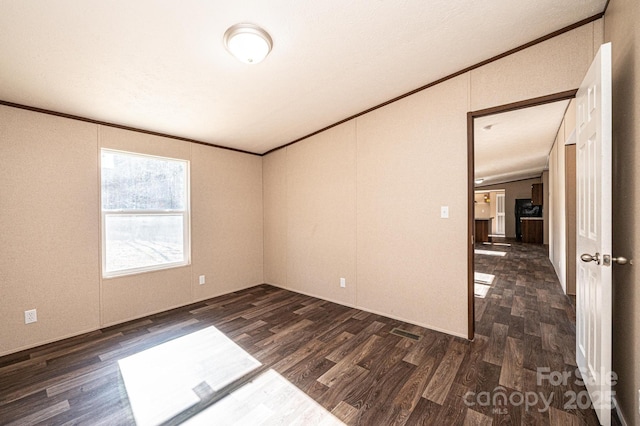 empty room featuring crown molding and dark hardwood / wood-style floors