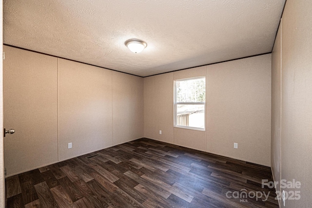 unfurnished room with dark wood-type flooring, ornamental molding, and a textured ceiling