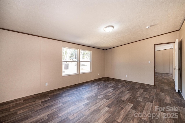 spare room featuring ornamental molding, dark hardwood / wood-style floors, and a textured ceiling