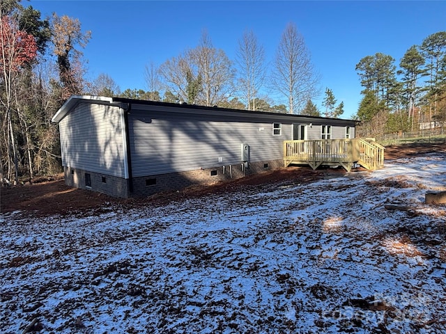 snow covered property with a deck