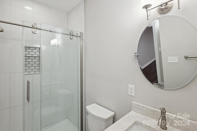 bathroom with vanity, toilet, and an enclosed shower