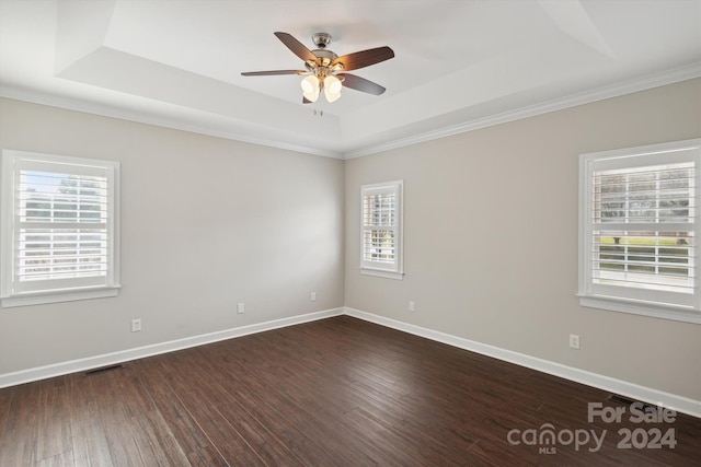 unfurnished room featuring dark hardwood / wood-style floors, ceiling fan, a raised ceiling, and crown molding