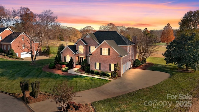 view of front of home with a garage and a yard