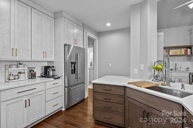 kitchen featuring dark hardwood / wood-style flooring, backsplash, high end fridge, sink, and white cabinetry