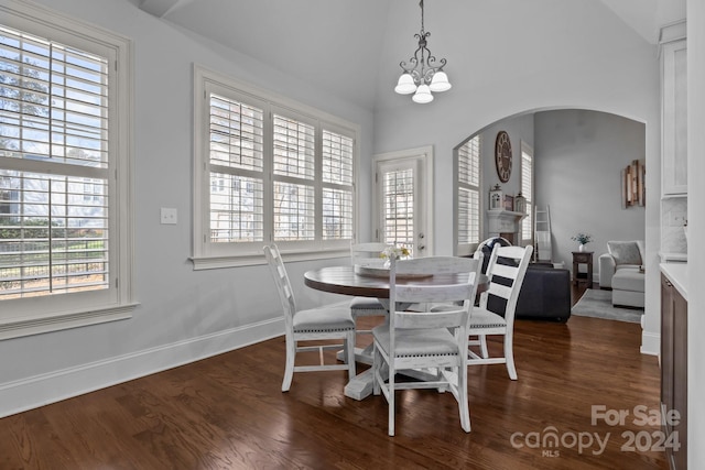 dining room with a chandelier, dark hardwood / wood-style flooring, and vaulted ceiling