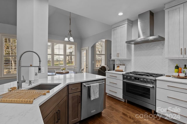 kitchen with dark wood-type flooring, stainless steel appliances, a healthy amount of sunlight, and wall chimney range hood