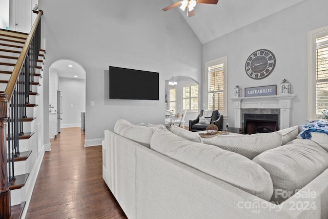 living room featuring a tile fireplace, ceiling fan, plenty of natural light, and dark hardwood / wood-style flooring