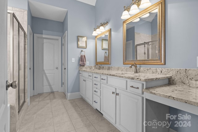 bathroom with vanity, tile patterned floors, and a shower with door