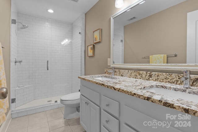 bathroom featuring tile patterned flooring, vanity, a shower with door, and toilet