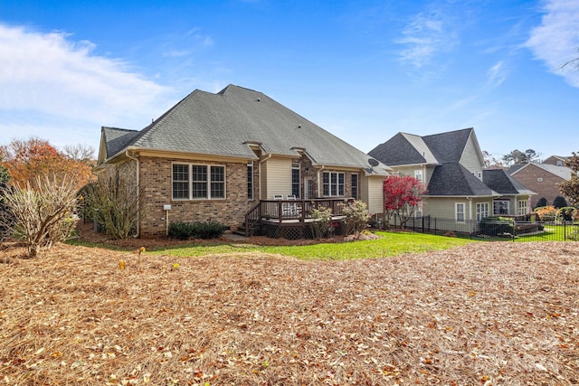 rear view of property featuring a lawn and a wooden deck