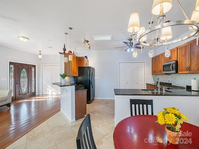 kitchen featuring decorative light fixtures, light wood-type flooring, stainless steel appliances, and kitchen peninsula