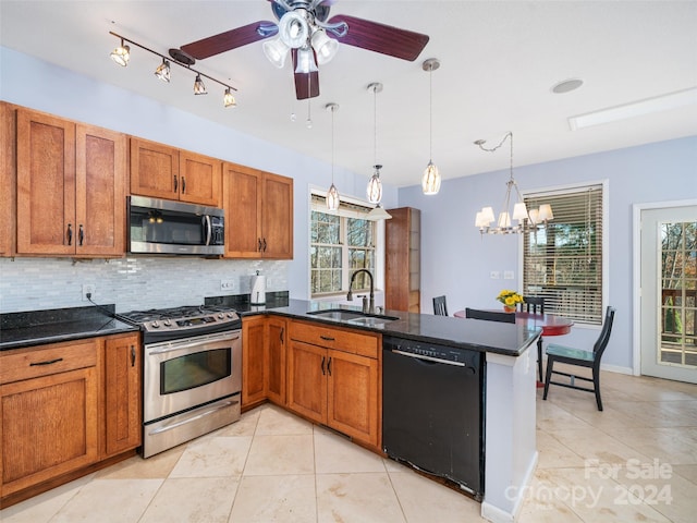 kitchen with hanging light fixtures, sink, stainless steel appliances, and plenty of natural light