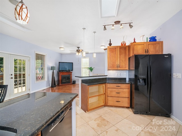 kitchen featuring decorative light fixtures, a healthy amount of sunlight, and black fridge