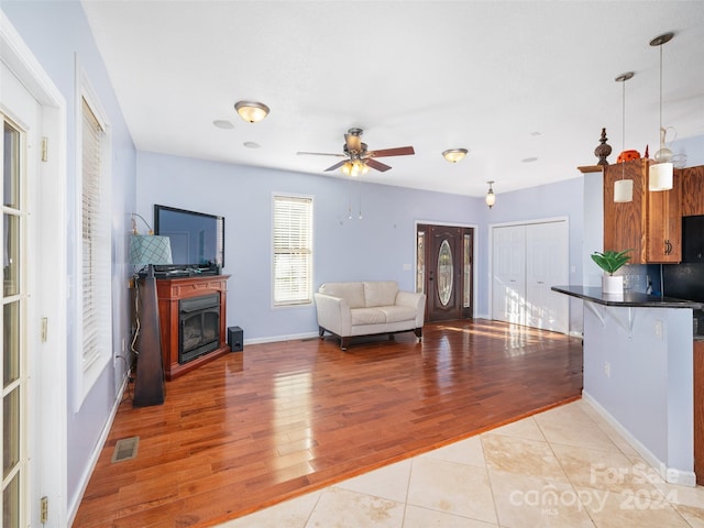 living room with ceiling fan and light hardwood / wood-style flooring