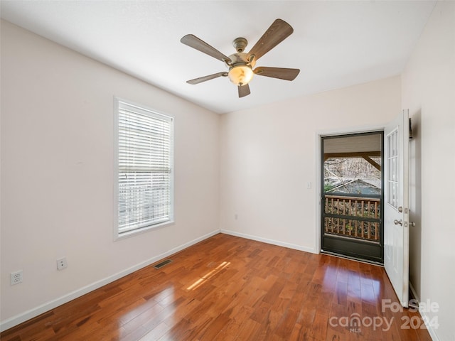 unfurnished room with a wealth of natural light, ceiling fan, and wood-type flooring