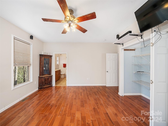 unfurnished bedroom with light wood-type flooring, ceiling fan, and connected bathroom