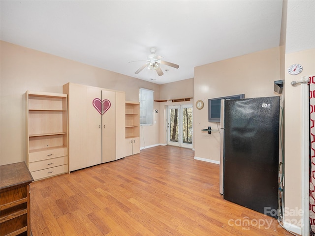 kitchen featuring ceiling fan, black refrigerator, and light hardwood / wood-style floors