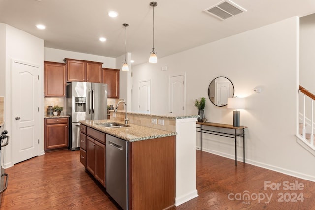 kitchen featuring sink, stainless steel appliances, dark hardwood / wood-style floors, an island with sink, and decorative light fixtures