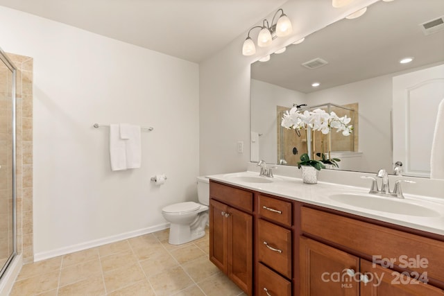 bathroom featuring tile patterned floors, vanity, an enclosed shower, and toilet