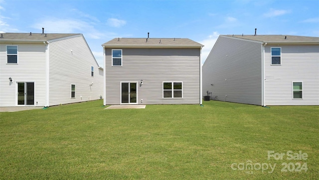 back of house with central air condition unit, a yard, and a patio