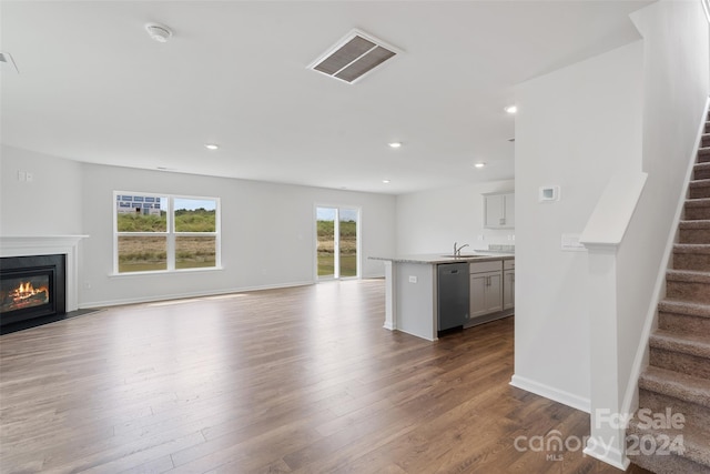 unfurnished living room with sink and hardwood / wood-style flooring