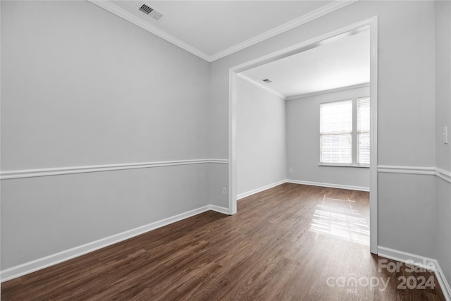 empty room with dark hardwood / wood-style floors and ornamental molding